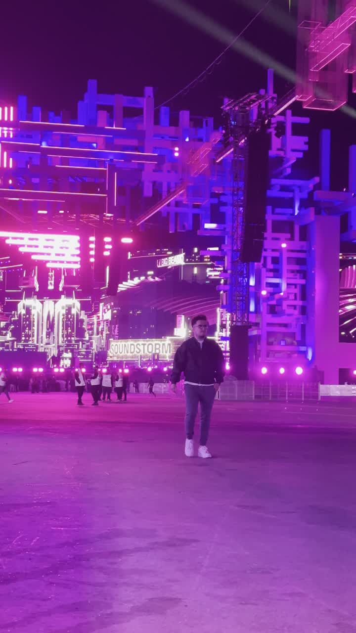 أجواء ليلية في منطقة الأنشطة الخارجية ، مهرجان ساوندستورم ميدل بيست في منطقة بانبان في مدينة الرياض، ١٣ ديسمبر ٢٠٢٥ في المملكه العربيه السعوديه ،إضاءة بنفسجية قوية تمتد على المسار المفتوح، زوار يتجولون وسط أجواء ممتعة ومليئة بالتسلية والترفيه، تجربة عائلية وشبابية ضمن فعاليات موسم الرياض