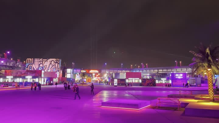 مهرجان ساوندستورم ميدل بيست في منطقة بانبان في مدينة الرياض، ١٣ ديسمبر ٢٠٢٥ في المملكه العربيه السعوديه ، أجواء ليلية في منطقة الأنشطة الخارجية ، إضاءة بنفسجية قوية تمتد على المسار المفتوح، زوار يتجولون وسط أجواء مليئة بالتسلية والترفيه، تجربة عائلية وشبابية ضمن فعاليات موسم الرياض