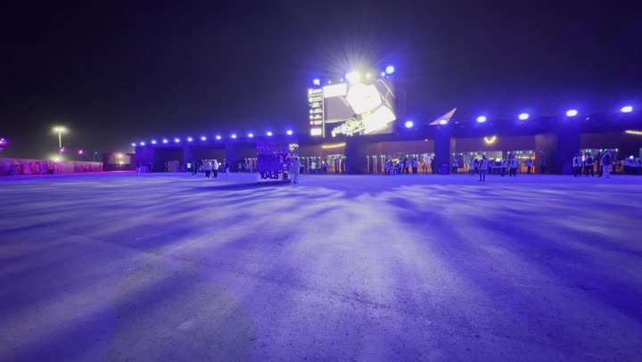 أجواء ليلية في منطقة الأنشطة الخارجية ، مهرجان ساوندستورم ميدل بيست في منطقة بانبان في مدينة الرياض، ١٣ ديسمبر ٢٠٢٥ في المملكه العربيه السعوديه ،إضاءة زرقاء قوية تمتد على المسار المفتوح، زوار يتجولون وسط أجواء مليئة بالتسلية والترفيه، تجربة عائلية وشبابية ضمن فعاليات موسم الرياض