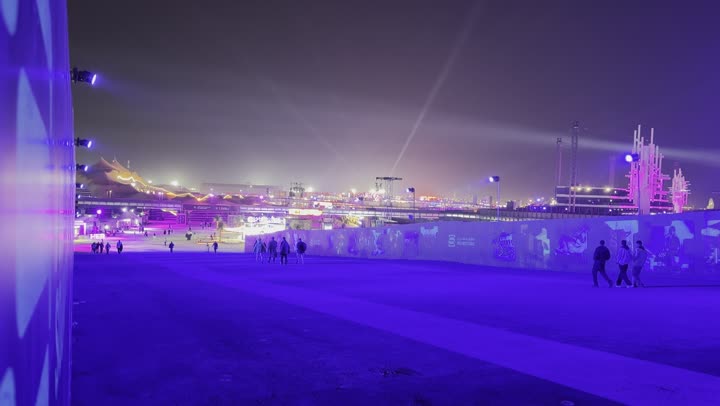 زوار يتجولون وسط أجواء ممتعة ومليئة بالتسلية والترفيه، أجواء ليلية في منطقة الأنشطة الخارجية مهرجان ساوندستورم ميدل بيست في منطقة بانبان في مدينة الرياض،  ١٣ ديسمبر ٢٠٢٥  في المملكه العربيهالسعوديه، إضاءة زرقاء قوية تمتد على المسار المفتوح، تجربة عائلية وشبابية ضمن فعاليات موسم الرياض