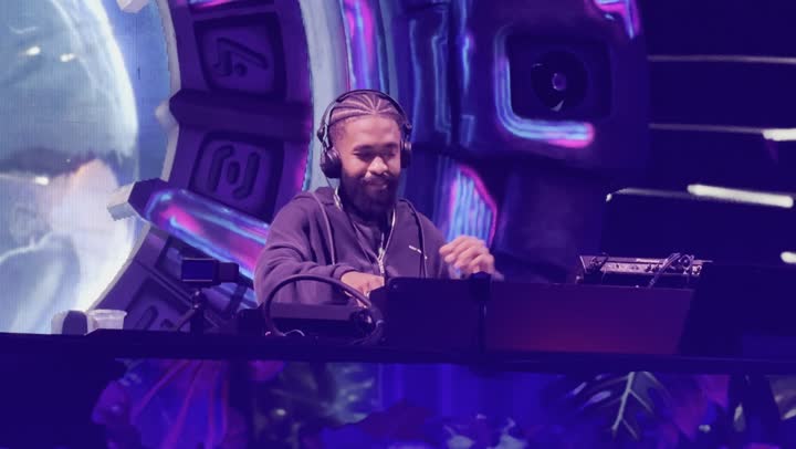 دي جي يقوم بوضع الموسيقى بإيماءات الاستمتاع منصة مهرجان ساوندستورم ميدل بيست في منطقة بانبان بمدينة الرياض، ١٣ ديسمبر ٢٠٢٥ في المملكه العربيه السعوديه، فعالية موسم الرياض تجربه فنيه موسيقيه حديثه ترفيهيه، احتفال عالمي للموسيقى والفن، خلفية مجسمات مضيئة ثلاثية الابعاد