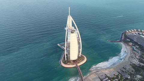 The growth and urban development on the Arabian Gulf coast, the architectural engineering art of towers and skyscrapers, attracting and drawing tourists from around the world, the Burj Al Arab hotel in Dubai, the tourist facade in the United Arab Emirates.