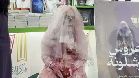 مركز الأدب العربي، تصوير لمجسم يرتدي فستان زفاف وردي اللون، أداة ترويجية لرواية بعنوان "عروس برشلونة"، معرض الكتاب الدولي في جدة 16 من ديسمبر 2025 ، المعالم والأماكن السياحية الثقافية المشهورة فى المملكة العربية السعودية، استقطاب وجذب السياح من أنحاء العالم ، فعاليات موسم الرياض