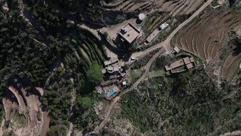 The green trees and plants on the slopes of the Jabal Fayfa mountains, aerial drone photography of nature in Jazan, Saudi Arabia, houses and residential buildings on the peaks and mountain heights, agricultural terraces in the city of Jazan in Saudi Arabia, nature background.