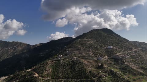 Aerial drone photography of nature in Jazan, Saudi Arabia, featuring green trees and plants on the slopes of the Faifa mountains, houses and residential buildings on the peaks and highlands, agricultural terraces in the city of Jazan in Saudi Arabia, natural background.