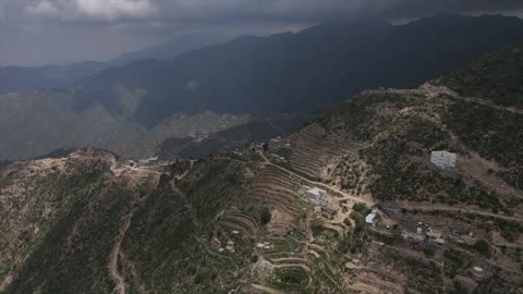 Aerial drone photography of nature in Jazan, Saudi Arabia, featuring green trees and plants on the slopes of the Faifa mountains, houses and residential buildings on the peaks and highlands, agricultural terraces in the city of Jazan in Saudi Arabia, natural background.