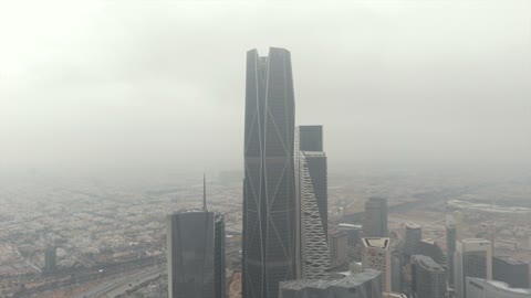 Famous landmarks of Riyadh, aerial drone photography of the King Abdullah Financial Center (KAFD), the illuminated financial and economic towers in the city of Riyadh, the architectural engineering art of the towers and skyscrapers in the Kingdom of Saudi Arabia, famous places and landmarks, a view of the sky filled with clouds.