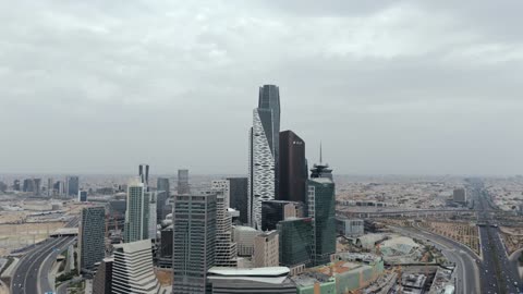 Famous landmarks of Riyadh, aerial drone photography of the King Abdullah Financial Center (KAFD), the illuminated financial and economic towers in the city of Riyadh, the architectural engineering art of the towers and skyscrapers in the Kingdom of Saudi Arabia, famous places and landmarks, a view of the sky filled with clouds.