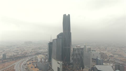 The view of the sky filled with clouds, aerial drone photography of the King Abdullah Financial Center (KAFD), the famous landmarks of Riyadh, the illuminated financial and economic towers in the city of Riyadh, the architectural engineering art of the towers and skyscrapers in the Kingdom of Saudi Arabia, the famous places and landmarks.