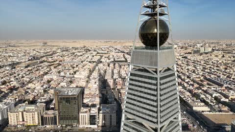 Aerial drone photography of the Kingdom Tower and Al Faisaliah Tower, famous landmarks of Riyadh, the illuminated financial and economic towers in the city of Riyadh, the architectural engineering art of the towers and skyscrapers in the Kingdom of Saudi Arabia, the famous places and landmarks.