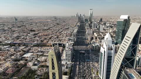 Aerial drone photography of the Kingdom Tower and Al Faisaliah Tower, famous landmarks of Riyadh, the illuminated financial and economic towers in the city of Riyadh, the architectural engineering art of the towers and skyscrapers in the Kingdom of Saudi Arabia, the famous places and landmarks.