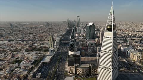 Aerial drone photography of the Kingdom Tower and Al Faisaliah Tower, famous landmarks of Riyadh, the illuminated financial and economic towers in the city of Riyadh, the architectural engineering art of the towers and skyscrapers in the Kingdom of Saudi Arabia, the famous places and landmarks.