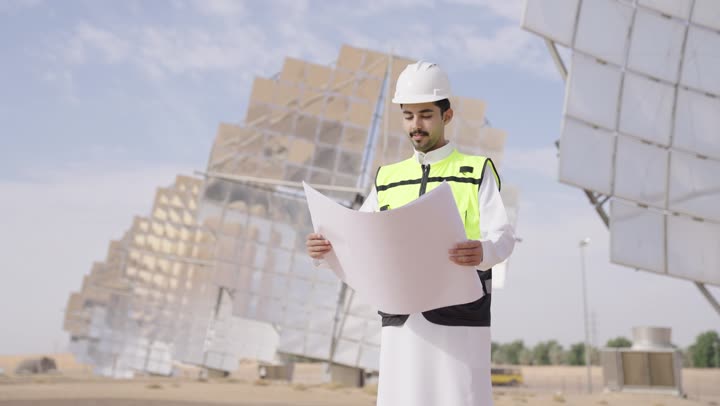 الرقابة على المشروع الهندسي, مهندس عربى خليجى سعودى يمسك مخطط و تصميم هندسى , إرتداء خوذة وسترة الحماية, مهن ووظائف سعودية، محطات الطاقة الشمسية