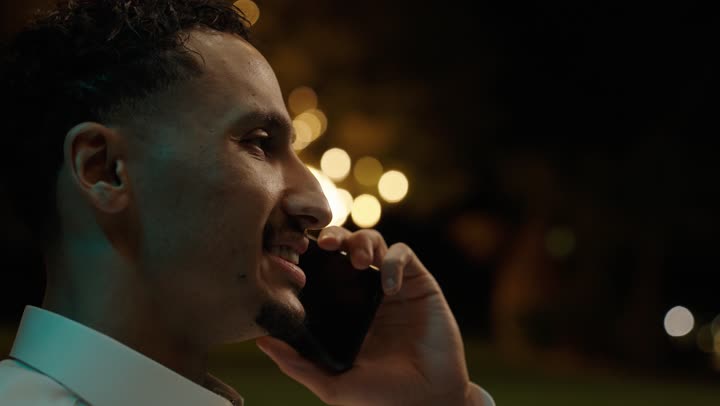 قضاء وقت ممتع في الهواء الطلق، استخدام الاجهزة التقنية الحديثة, إجراء مكالمه صوتية عبر الهاتف المحمول،تصويرمقرب لرجل عربي خليجي سعودي يرتديالثوب التقليدي يمسك بيدية الهاتف المحمول، دردشه ومحادثات مع الاصدقاء والاقارب