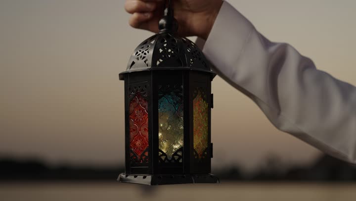المناسبات الدينية والأعياد الإسلامية ، تصوير مقرب ليد رجل عربي خليجي سعودي يقف فى الهواء الطلق يحمل فانوس رمضان ، الإستعداد لقدوم شهر رمضان المبارك