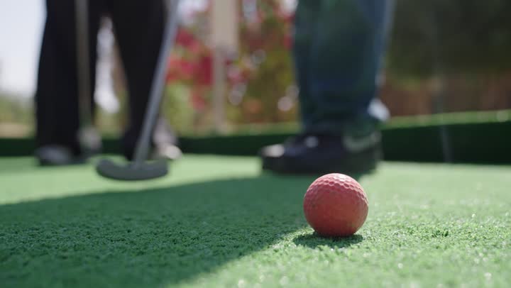 تحديد وتصويب الهدف، تصوير مقرب لرجل عربي خليجي سعودي يرتدي الزي الكاجوال يقوم  بشوط كره الغولف على مساحات واسعة خضراء، أنشطة رياضية بالسعودية