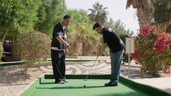 رياضات الألعاب الأولمبية الصيفية، شابان عربيان خليجيان سعوديان يرتديان الزي الكاجوال يقومان بممارسة لعبة الغولف على مساحات واسعة خضراء، أنشطة رياضية بالسعودية