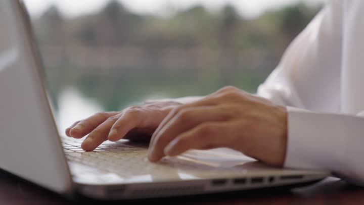 النقر على لوحة المفاتيح ، تصوير مقرب ليد رجل عربي خليجي سعودي يستخدم الحاسب المحمول، مفهوم العمل عن بعد