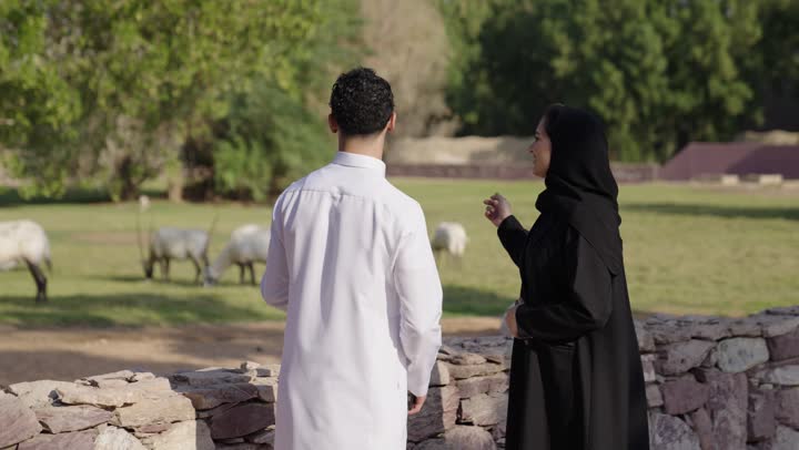 تعابير الموافقة و القبول، قضاء عطلة صيفية ، زوجان عربيان خليجيان سعوديان يرتدي الزي التقليدي يقومان بالتقاط صورة سيلفي عبر الهاتف المحمول، نزهه في الهواء الطلق، ايماءات السعادة و السرور، أنشطة ترفيهية عائلية