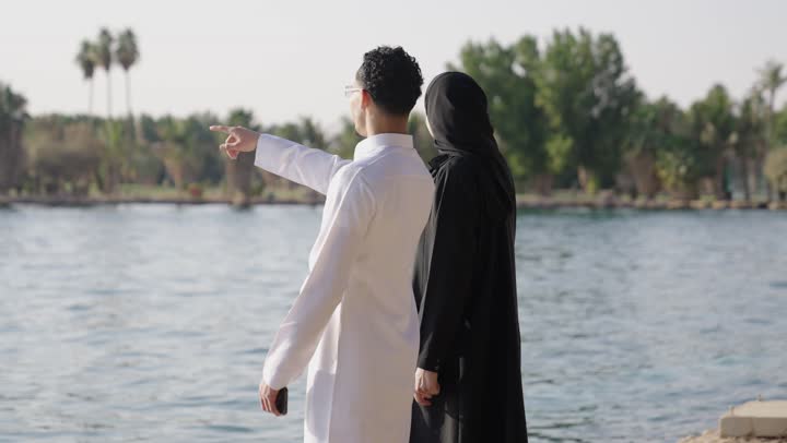 توثيق لحظات السفر والتصوير التذكاري، قضاء أوقات عائلية ممتعة, التفاهم والترابط الفكري بين الزوجين، التنزه فى الهواء الطلق ، رجل عربي خليجي سعودي يرتدي الثوب الابيض يقوم بالتقاط الصورعبر الهاتف المحمول