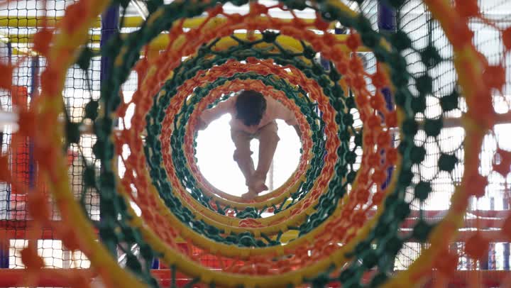 محاولة الوصول لنهاية النفق و الوصول للجانب الاخر ,طفل عربي سعودي خليجي يرتدي الزي الكاجوال يمشي خطوات صغيرة متتابعة داخل الانفاق ,تعلم مهارات جديدة اثناء تقضية اوقات مسلية , الاستمتاع باللعب في مدينة الملاهي