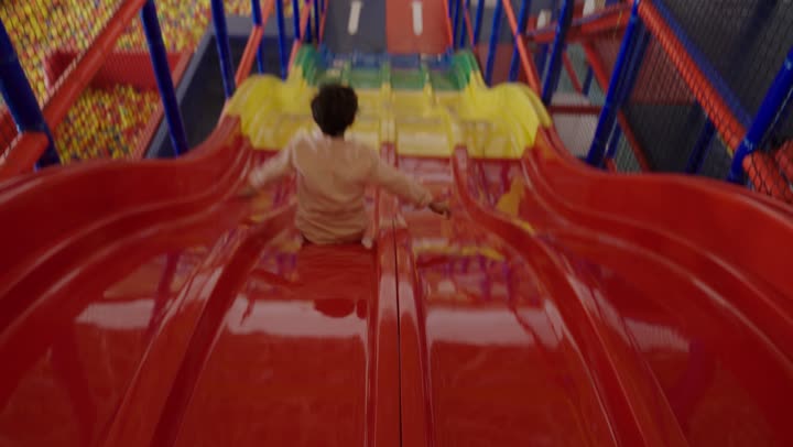 التزلج على الزحلوقة وتقضية الاوقات المسلية ,نشاط ترفيهي مميز ,طفل عربي خليجي سعودي يرتدي الزي الكاجوال يستمتع بالسرعة في التزلج للاسفل ,الاستمتاع باللعب في مدينة الملاهي