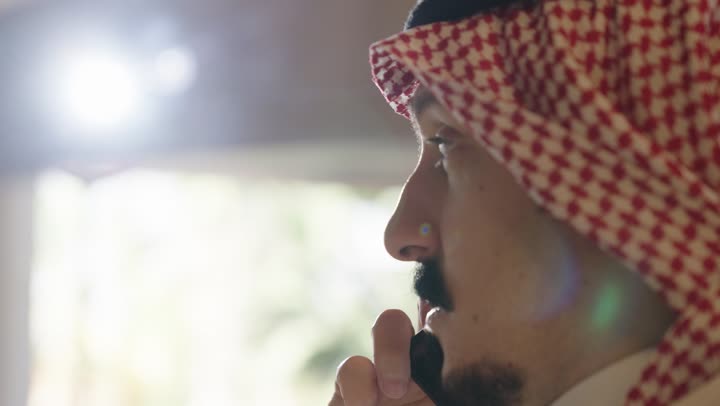 العديد من الخيارات المتاحة لاجراء مكالمات صوتية ,رجل عربي خليجي سعودي يرتدي الزي التقليدي يتحدث في الهاتف المحمول للاطمئنان على الاهل و متابعة العمل ,مفهوم البقاء متصل مع العائلة و الاصدقاء ,تصوير مقرب من الجانب