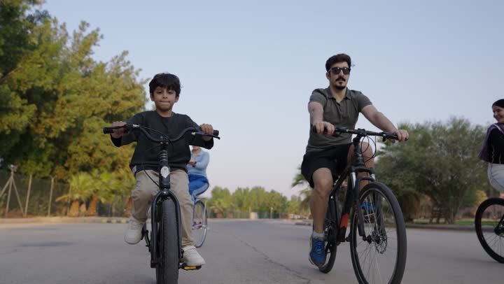 ركوب الدراجات الهوائية وسط الحديقة ,عائلة عربية خليجية سعودية يقضون اوقات عائلية مميزة وسط الاجواء المعتدلة الدافئة ,فتيات سعوديات يرتدين الزي الكاجوال