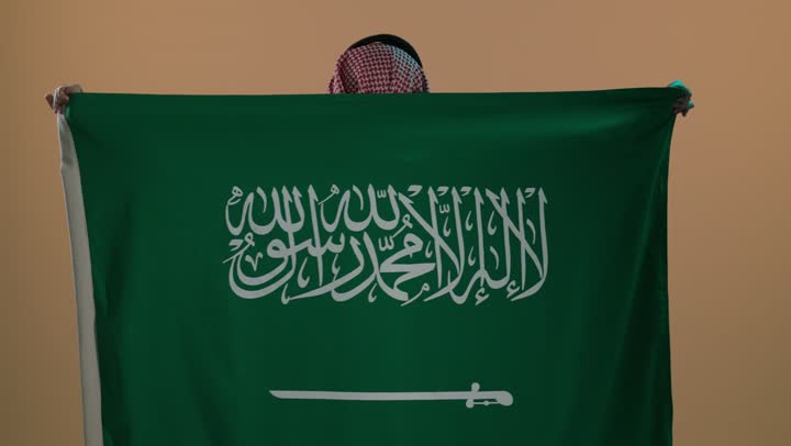 شعار الهوية الوطنية وراية الإسلام والتوحيد، الفخر والاعتزاز بإنجازات الوطن، بورتريه لرجل عربي خليجي سعودي يرتدي الثوب و الشماغ يضع علم التأسيس على كتفية , ذكرى تأسيس الدولة السعودية الأولى 22 فبراير، خلفية بنية