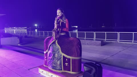 An artist performing a musical show on the saxophone, the tourist waterfront during the events of the Wonders Hills Festival 2025 in the city of Jubail Industrial in the Eastern Province, Jubail Corniche, innovative interactive light shows, various recreational activities, famous tourist attractions.
