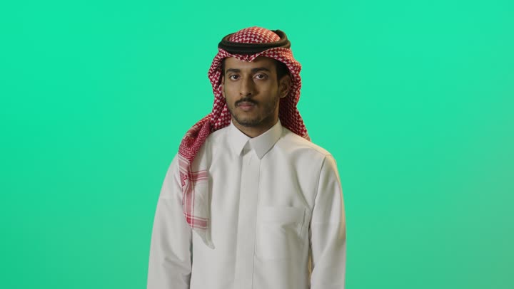 طلب خفض الصوت والتهديد، النهي عن فعل شيء ما, الصمت والتوقف عن الكلام, بورترية لشاب عربي خليجي سعودي يرتدي الثوب الابيض و الشماغ يرفع كفه للأعلى بإيماءات الرفض وعدم الرضى والقبول, خلفية خضراء، كروما