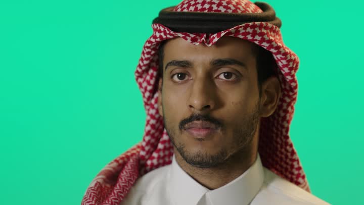 النهي عن فعل شيء ما, الصمت والتوقف عن الكلام, بورترية مقرب لشاب عربي خليجي سعودي يرتدي الثوب الابيض و الشماغ يرفع كفه للأعلى بإيماءات الرفض وعدم الرضى والقبول, طلب خفض الصوت والتهديد, خلفية خضراء، كروما