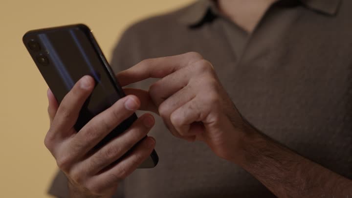 التصفح على الهاتف المحمول واستخدام خاصية التقريب الصورة لرؤية أوضح , رجل عربي خليجي سعودي يرتدي الزي الكاجوال يتصفح الجوال لمشاهدة الصور الممتعة الجميلة