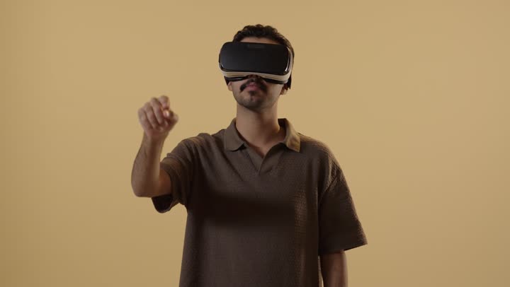اشارات تقريب و تحريك الصور في الهواء , رجل عربي خليجي سعودي يرتدي الزي الكاجوال يلبس نظارة العالم الافتراضي ويعيش تجربة محاكاة حقيقية , تعابير الدهشة مع التركيز