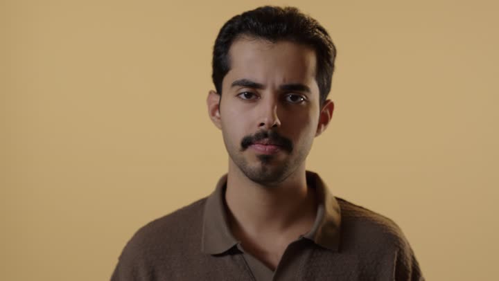 وضع اصبع الابهام للاسفل علامة على عدم الاعجاب بشئ ما, رجل عربي خليجي سعودي يرتدي الزي الكاجوال , وجه عابس متجهم , تعابير الغضب و الضيق