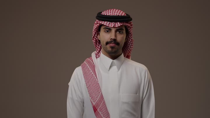ايماءات الفرحة و السعادة , رجل عربي خليجي سعودي يرتدي الثوب الابيض التقليدي , رفع اصبع الابهام لاعلى اشارة الي الاعجاب بشئ ما , تعابير وجه راضية و سعيدة