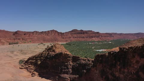 وسط الصحراء مساحة خضراء، مسار للمشي بين أشجار النخيل والحمضيات، من المزرعة إلى المائدة، تصوير درون لمزارع العلا في المملكة العربية السعودية،  أكبر المزارع التي توفر خيارات للإقامة الريفية