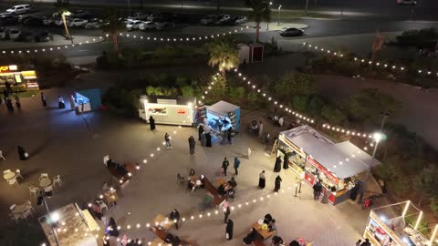 مكان لقضاء وقت ممتع مع العائلة في المملكة العربية السعودية، الفن الهندسي المعماري على الطراز الحديث، وجهة تسوق وترفيه عائلية ، تصوير درون للبارك مول في وقت الليل على طريق الملك فيصل في حي مروج الأمير في مدينة تبوك