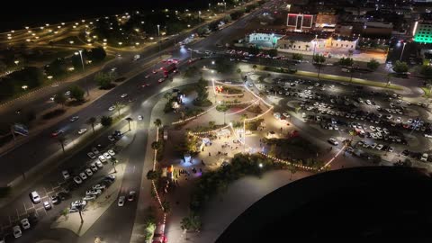 وجهة تسوق وترفيه عائلية ، تصوير درون للبارك مول في وقت الليل على طريق الملك فيصل في حي مروج الأمير في مدينة تبوك، الفن الهندسي المعماري على الطراز الحديث، مكان لقضاء وقت ممتع مع العائلة في المملكة العربية السعودية
