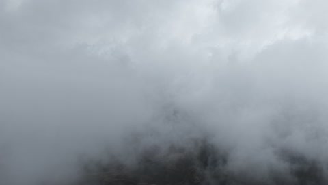 تساقط البرد (حبات الثلج الصغيرة) فوق منطقة الحرات البركانية في تبوك، الجو الشتوي الضبابي فوق الجبل في سماء مدينة حرة تبوك في المملكة العربية السعودية