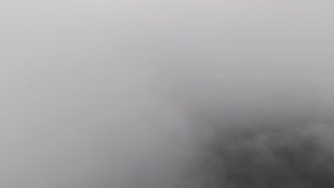 تساقط البرد (حبات الثلج الصغيرة) فوق منطقة الحرات البركانية في تبوك، الجو الشتوي الضبابي فوق الجبل في سماء مدينة حرة تبوك في المملكة العربية السعودية