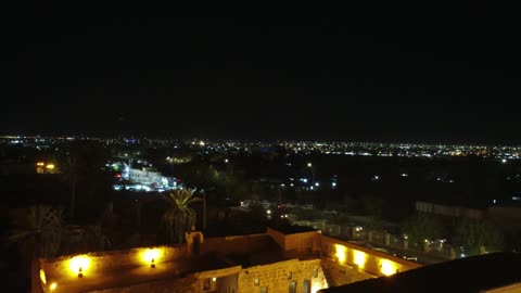 فناء تطل عليه عدد من الحجرات ومسجد وبئر، رجال يرتدون الزي التقليدي الثوب والشماغ، قلعة تبوك معلم تاريخي يقع في وسط مدينة تبوك في المملكة لعربية السعودية، رممت القلعة مؤخرًا والآن وجهة تاريخية وثقافية وسياحية