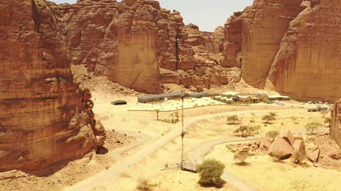 A resort amidst the desert landscapes in Al-Ula Valley in Saudi Arabia, modern comfort and authentic Arab architecture, a large outdoor pool, landmarks and tourist attractions.
