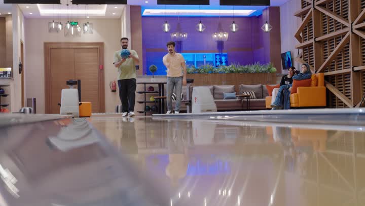 The competition among friends in bowling, precision and professionalism in throwing the ball, family gatherings for fun and entertainment in the bowling alley, a family recreational activity.