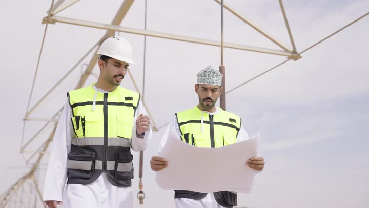 تقدم وتطور السعودية على يد أبناء الوطن,  مهندسان عربيان خليجيان عمانيان يشرفان على محطات الطاقة الشمسية ، إرتداء خوذة وسترة الحماية ، الإشراف على العمل، ستلايت، أنظمة الطاقة الشمسية,  تبادل الخبرة و الرأى