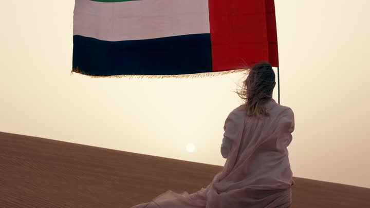 تصوير من الخلف لامراة عربية خليجية اماراتية ترتدي العباءة تقف فى الصحراء,  ايماءات السعادة والفخر والاعتزاز، مفهوم حب الوطن والانتماء اليه, حب الوطن والانتماء اليه، الاحتفال بذكرى استقلال دولة الإمارات العربية المتحدة