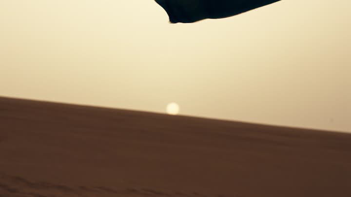 رجل عربي خليجي اماراتي يرتدي الكندورة والغترة يمشى فى الصحراء برفقة زوجته يمسك بيدية علم الامارات، ايماءات السعادة والفخر والاعتزاز، اليوم الوطني الإماراتي 2 ديسمبر، ذكرى استقلال دولة الإمارات العربية المتحدة، حب الوطن والانتماء اليه