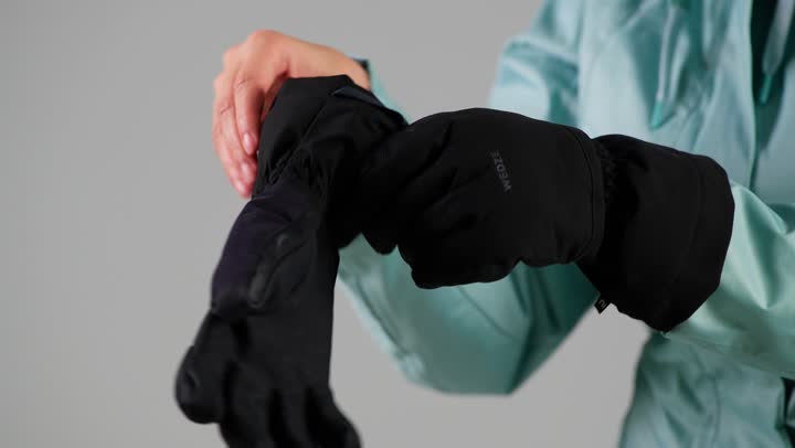 ارتداء القفاز الاسود الثقيل لحماية الاصابع من اللمسات الباردة , امرأة عربية خليجية سعودية ترتدي ملابس التزلج على الجليد , الاستعداد لبدء النشاط المسلي , امرأة اماراتية , تصوير مقرب