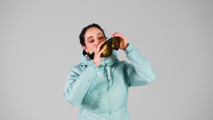 امرأة عربية خليجية سعوجية ترتدي ملابس التزلج على الجليد الثقلية للشعور بالدفء ,ارتداء النظارةالجليدية لحماية العين من قطع الثلج الصغيرة , ايماءات السعادة و الفرحة , امرأة اماراتية