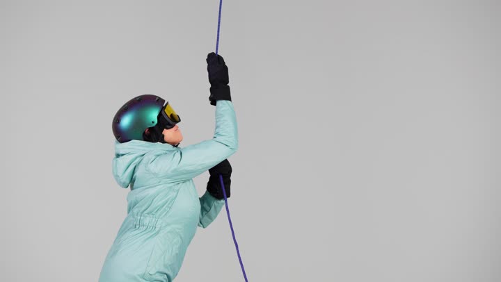 ممارسة لعبة التسلق على الحبل للوصول الى قمة الجبل , امرأة اماراتية ترتدي ملابس التزلج على الجليد الثقيلة لتشعر بالدفء , ارتداء خوذة الرأس لزيادة الامان ,